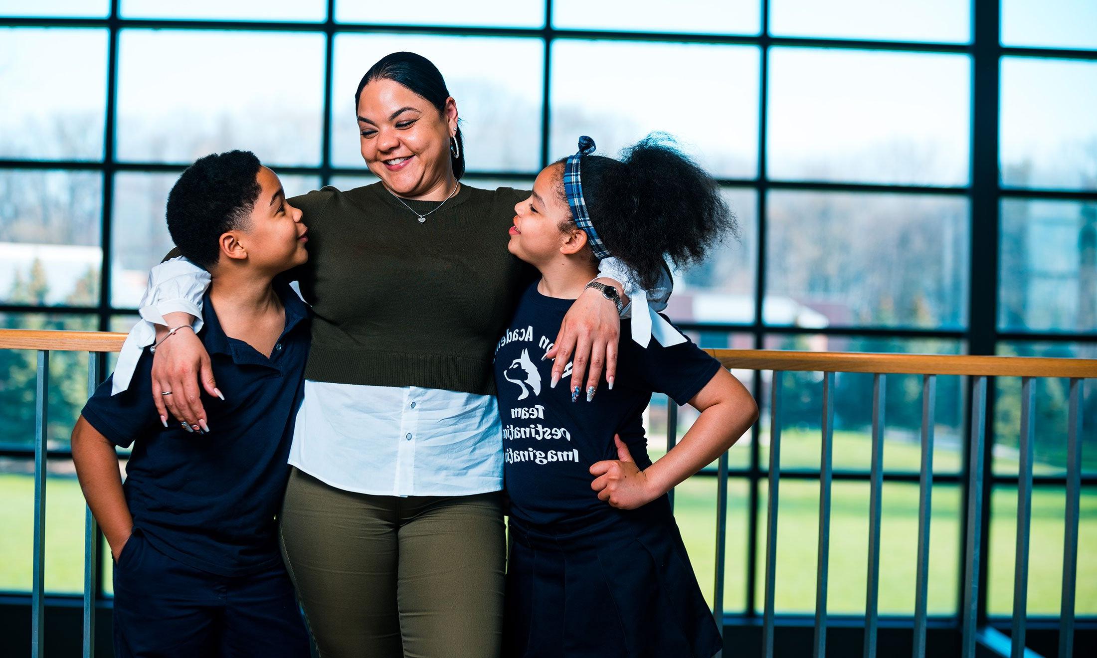 A woman with her arms around two children.